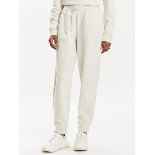 Asics Spodnie dresowe Logo 2032C844 Beżowy Regular Fit ze sklepu MODIVO w kategorii Spodnie damskie - zdjęcie 182666968