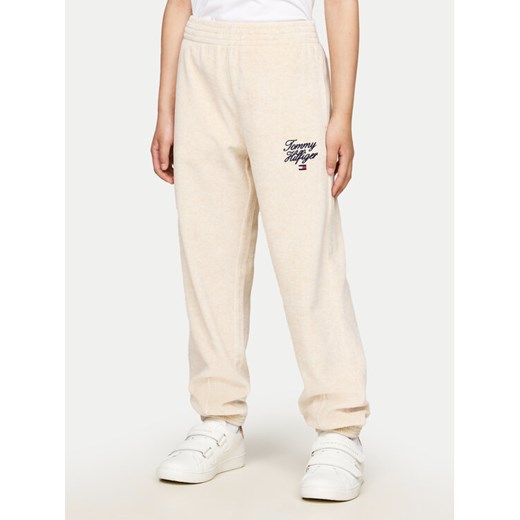Tommy Hilfiger Spodnie dresowe Script Velour KG0KG08221 Beżowy Regular Fit ze sklepu MODIVO w kategorii Spodnie chłopięce - zdjęcie 182668987