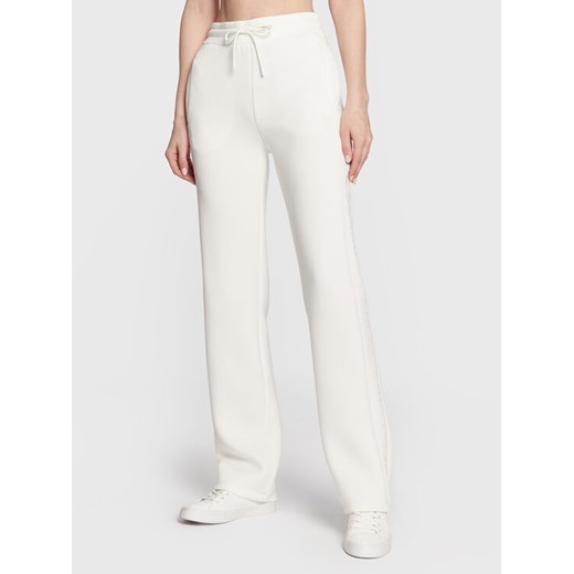 Guess Spodnie dresowe V3RB21 K7UW2 Écru Regular Fit ze sklepu MODIVO w kategorii Spodnie damskie - zdjęcie 182669516
