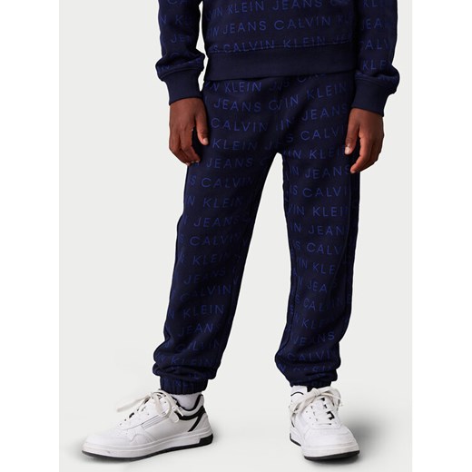 Calvin Klein Jeans Spodnie dresowe Ckj Aop Jogger IB0IB02323 Granatowy Regular Fit ze sklepu MODIVO w kategorii Spodnie chłopięce - zdjęcie 182693066