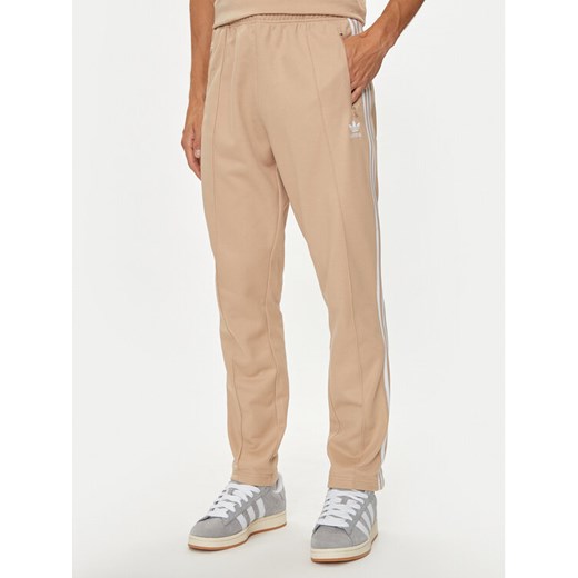 adidas Spodnie dresowe adicolor Classics Beckenbauer IZ1857 Beżowy Slim Fit ze sklepu MODIVO w kategorii Spodnie męskie - zdjęcie 182694467