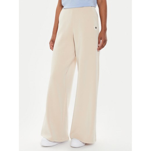 Guess Spodnie dresowe V4YB07 KCAY2 Beżowy Relaxed Fit ze sklepu MODIVO w kategorii Spodnie damskie - zdjęcie 182703649