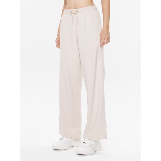 Tommy Hilfiger Spodnie dresowe UW0UW04771 Beżowy Relaxed Fit ze sklepu MODIVO w kategorii Spodnie damskie - zdjęcie 182709657