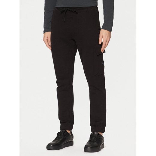 Calvin Klein Jeans Spodnie dresowe J30J326762 Czarny Regular Fit ze sklepu MODIVO w kategorii Spodnie męskie - zdjęcie 182711217