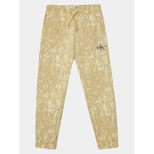 Calvin Klein Jeans Spodnie dresowe Second Skin IB0IB01932 Beżowy Relaxed Fit ze sklepu MODIVO w kategorii Spodnie chłopięce - zdjęcie 182716037