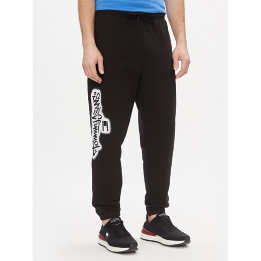 Tommy Jeans Spodnie dresowe Tjm Reg Tommy Spray Sweatpant DM0DM18376 Czarny Regular Fit ze sklepu MODIVO w kategorii Spodnie męskie - zdjęcie 182717419