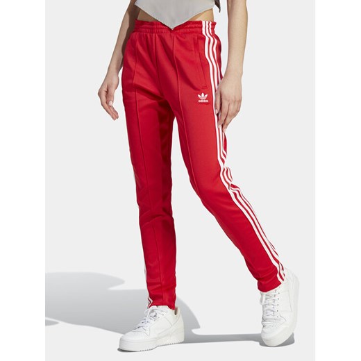 adidas Spodnie dresowe adicolor SST IK6603 Czerwony Slim Fit ze sklepu MODIVO w kategorii Spodnie damskie - zdjęcie 182717536