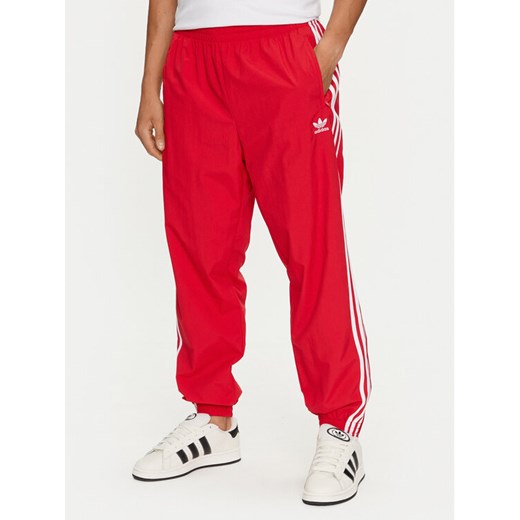 adidas Spodnie dresowe Adicolor Woven Firebird IT2498 Czerwony Regular Fit ze sklepu MODIVO w kategorii Spodnie męskie - zdjęcie 182727207