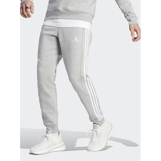 adidas Spodnie dresowe Essentials Fleece 3-Stripes Cuff IJ6494 Szary Regular Fit ze sklepu MODIVO w kategorii Spodnie męskie - zdjęcie 182727787