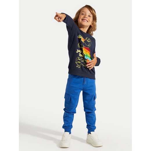 Coccodrillo Spodnie dresowe ZC4120201DBK Niebieski Slim Fit ze sklepu MODIVO w kategorii Spodnie chłopięce - zdjęcie 182729469