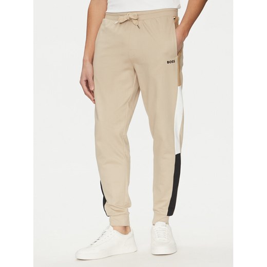 BOSS Spodnie dresowe Iconic 50535786 Beżowy Regular Fit ze sklepu MODIVO w kategorii Spodnie męskie - zdjęcie 182729495