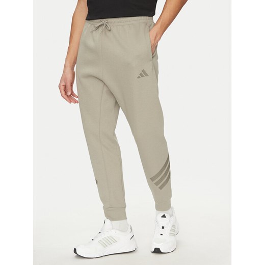 adidas Spodnie dresowe Future Icons 3-Stripes JD4862 Beżowy Regular Fit ze sklepu MODIVO w kategorii Spodnie męskie - zdjęcie 182729565