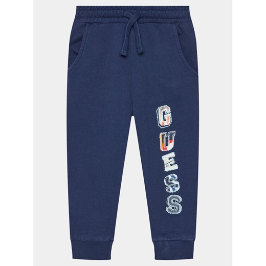 Guess Spodnie dresowe N4GQ11 KA6R3 Granatowy Regular Fit ze sklepu MODIVO w kategorii Spodnie chłopięce - zdjęcie 182730005