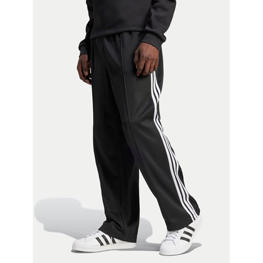 adidas Spodnie dresowe adicolor Firebird IZ4801 Czarny Baggy Fit ze sklepu MODIVO w kategorii Spodnie męskie - zdjęcie 182738338