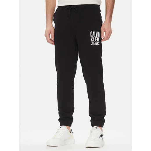Calvin Klein Jeans Spodnie dresowe Painted J30J327535 Czarny Regular Fit ze sklepu MODIVO w kategorii Spodnie męskie - zdjęcie 182750816