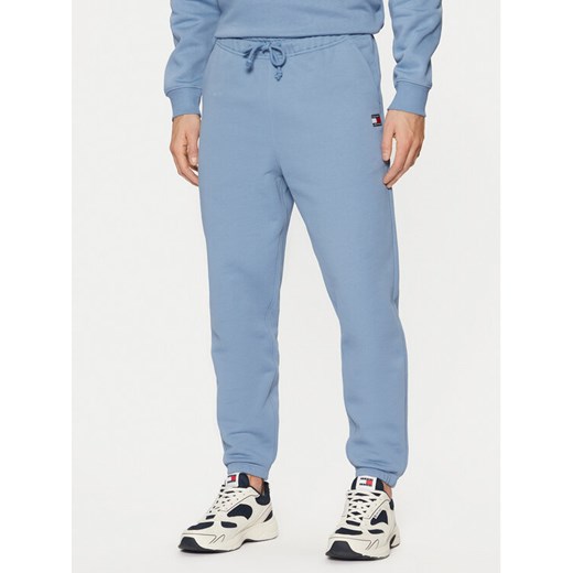 Tommy Jeans Spodnie dresowe Badge DM0DM20276 Niebieski Regular Fit ze sklepu MODIVO w kategorii Spodnie męskie - zdjęcie 182762886