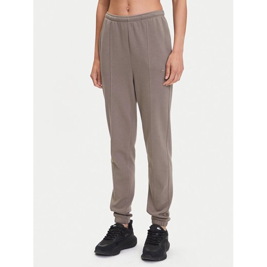Nike Spodnie dresowe Chill Terry FN2434 Brązowy Regular Fit ze sklepu MODIVO w kategorii Spodnie damskie - zdjęcie 183620318