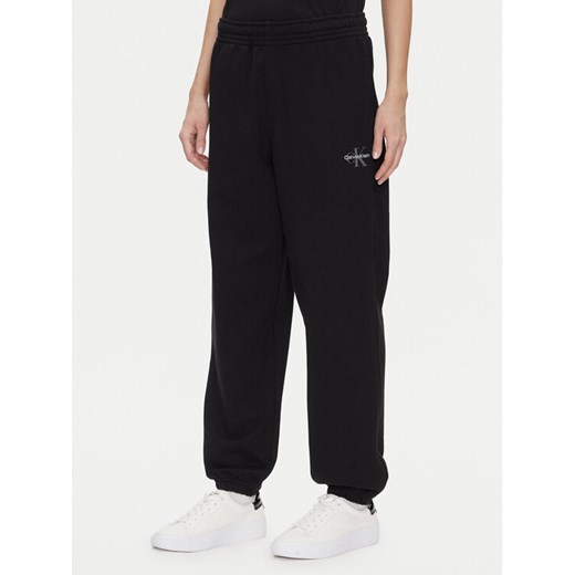 Calvin Klein Jeans Spodnie dresowe Monologo LV047B235G Czarny Regular Fit ze sklepu MODIVO w kategorii Spodnie damskie - zdjęcie 183813955