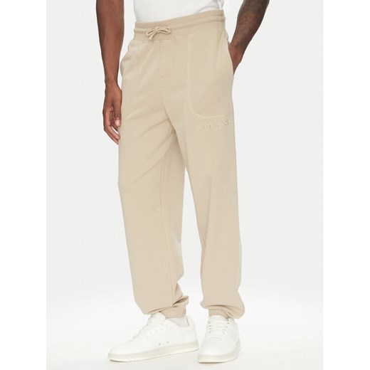 Guess Spodnie dresowe U5RB00 KCO31 Beżowy Regular Fit ze sklepu MODIVO w kategorii Spodnie męskie - zdjęcie 183814057