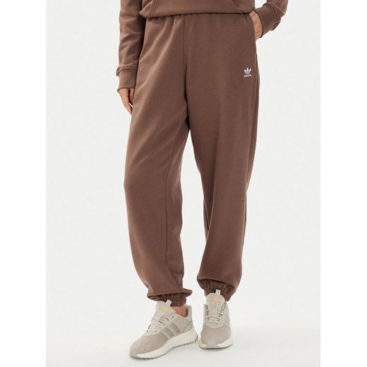 adidas Spodnie dresowe adicolor Essentials IR5974 Brązowy Regular Fit ze sklepu MODIVO w kategorii Spodnie damskie - zdjęcie 183885619