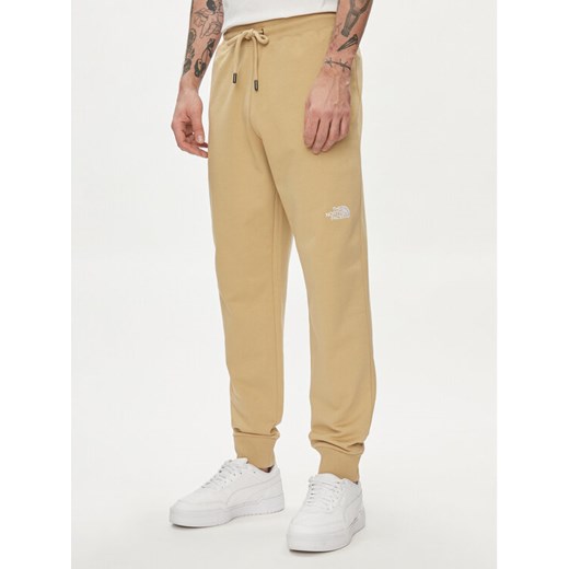 The North Face Spodnie dresowe Nse Light NF0A4T1F Beżowy Regular Fit ze sklepu MODIVO w kategorii Spodnie męskie - zdjęcie 183946837