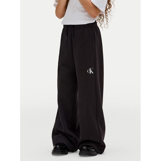 Calvin Klein Jeans Spodnie dresowe IG0IG02875 D Czarny Wide Leg ze sklepu MODIVO w kategorii Spodnie dziewczęce - zdjęcie 183985266