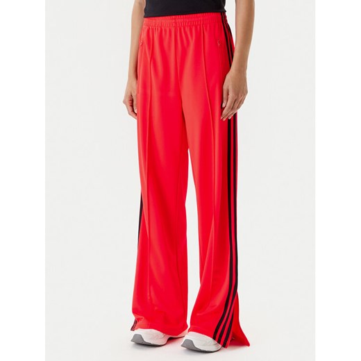 adidas Spodnie dresowe adicolor Classic Firebird JW1227 Pomarańczowy Loose Fit ze sklepu MODIVO w kategorii Spodnie damskie - zdjęcie 184019339