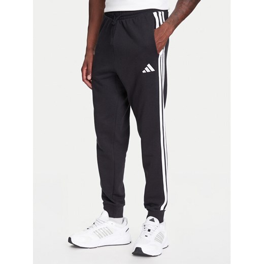 adidas Spodnie dresowe Essential 3-Stripes JD1881 Czarny Regular Fit ze sklepu MODIVO w kategorii Spodnie męskie - zdjęcie 184019446