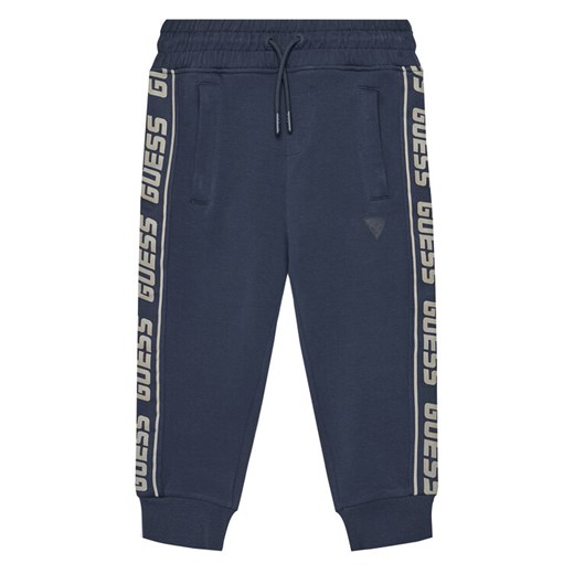 Guess Spodnie dresowe L2YQ48 K6ZS1 Granatowy Regular Fit ze sklepu MODIVO w kategorii Bluzy chłopięce - zdjęcie 184103357
