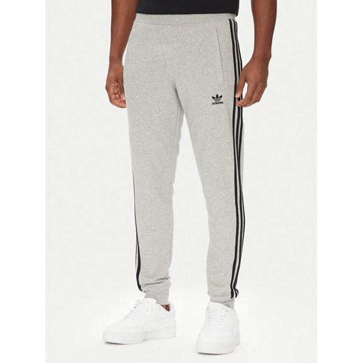 adidas Spodnie dresowe adicolor 3-Stripes JY1387 Szary Slim Fit ze sklepu MODIVO w kategorii Spodnie męskie - zdjęcie 184231798