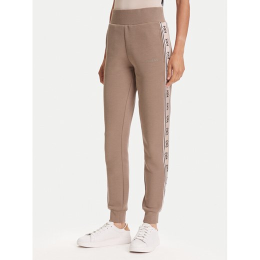 Guess Spodnie dresowe V2YB15 KB3P2 Brązowy Regular Fit ze sklepu MODIVO w kategorii Spodnie damskie - zdjęcie 184547039