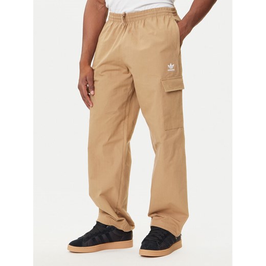 adidas Spodnie dresowe Trefoil Essentials JX3912 Beżowy Loose Fit ze sklepu MODIVO w kategorii Spodnie męskie - zdjęcie 184672767