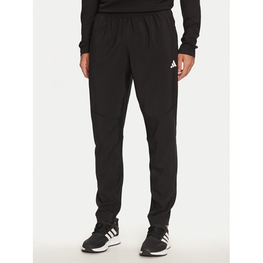adidas Spodnie dresowe Own The Run IK5024 Czarny Regular Fit ze sklepu MODIVO w kategorii Spodnie męskie - zdjęcie 185030907