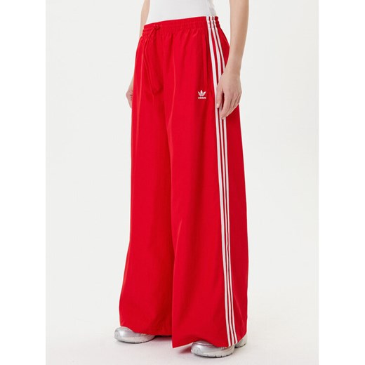 adidas Spodnie dresowe adicolor Firebird JD3388 Czerwony Loose Fit ze sklepu MODIVO w kategorii Spodnie damskie - zdjęcie 185039109