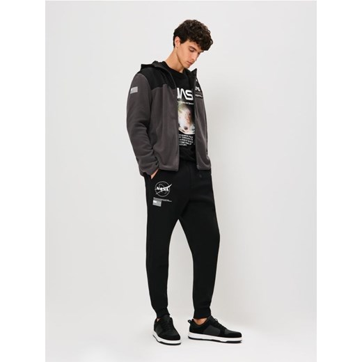 Sinsay - Spodnie tapered fit NASA - czarny - id: 035EV-99X - marki Sinsay - 186463998 Sinsay - Spodnie tapered fit NASA - czarny ze sklepu Sinsay w kategorii Spodnie męskie - zdjęcie 186463998