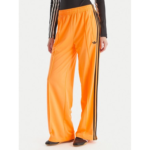 adidas Spodnie dresowe adicolor Classic Firebird JY2694 Żółty Loose Fit ze sklepu MODIVO w kategorii Spodnie damskie - zdjęcie 186521629