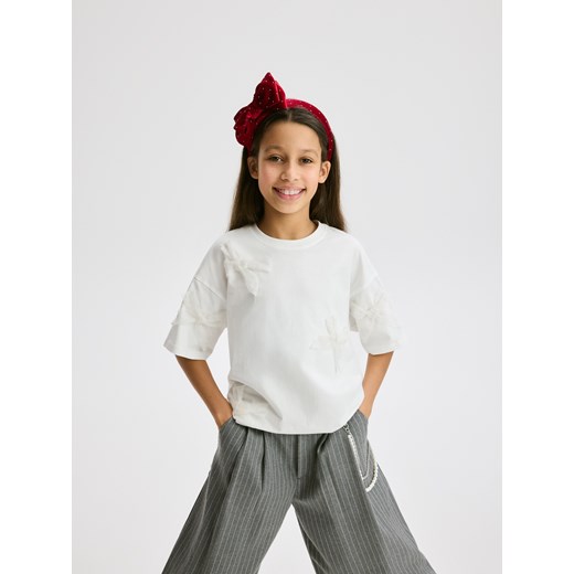 Reserved - T-shirt z kokardkami - złamana biel - id: 497FT-01X - marki Reserved - 187276816 Reserved - T-shirt z kokardkami - złamana biel ze sklepu Reserved w kategorii Bluzki dziewczęce - zdjęcie 187276816