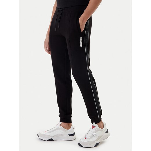 Guess Spodnie dresowe Mickey Z2YB09 KB3P2 Czarny Regular Fit ze sklepu MODIVO w kategorii Spodnie męskie - zdjęcie 187516476