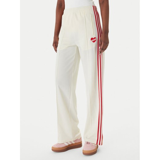 adidas Spodnie dresowe Firebird KQ8056 Beżowy Loose Fit ze sklepu MODIVO w kategorii Spodnie damskie - zdjęcie 189393065
