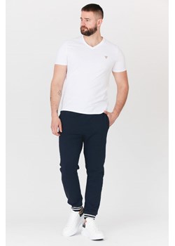 GUESS - Granatowe męskie spodnie dresowe ze sklepu outfit.pl w kategorii Spodnie męskie - zdjęcie 135575396