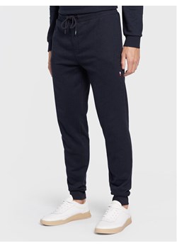 Tommy Hilfiger Spodnie dresowe UM0UM02667 Granatowy Relaxed Fit ze sklepu MODIVO w kategorii Spodnie męskie - zdjęcie 149732799