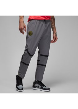 Męskie spodnie z tkaniny Paris Saint-Germain - Szary ze sklepu Nike poland w kategorii Spodnie męskie - zdjęcie 161526529