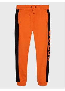 Guess Spodnie dresowe N3RQ12 KA6R3 Pomarańczowy Regular Fit ze sklepu MODIVO w kategorii Spodnie chłopięce - zdjęcie 168395355