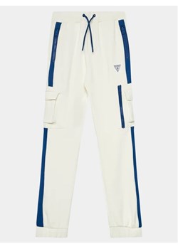 Guess Spodnie dresowe L4RQ14 KB212 Biały Relaxed Fit ze sklepu MODIVO w kategorii Spodnie chłopięce - zdjęcie 168402829