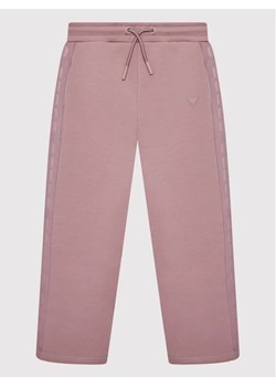 Guess Spodnie dresowe J2YQ26 FL03S Fioletowy Regular Fit ze sklepu MODIVO w kategorii Spodnie dziewczęce - zdjęcie 168405847