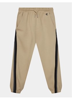 Calvin Klein Jeans Spodnie dresowe Interlock IB0IB01931 Beżowy Relaxed Fit ze sklepu MODIVO w kategorii Spodnie chłopięce - zdjęcie 168412789