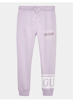Guess Spodnie dresowe J3YQ11 KA6R4 Fioletowy Relaxed Fit ze sklepu MODIVO w kategorii Spodnie dziewczęce - zdjęcie 168423787