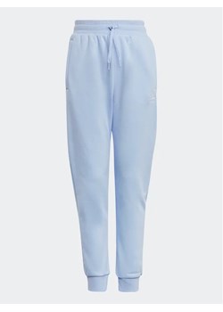adidas Spodnie dresowe Adicolor Joggers IC6133 Niebieski Regular Fit ze sklepu MODIVO w kategorii Spodnie dziewczęce - zdjęcie 168458239