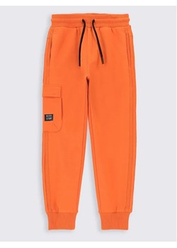 Coccodrillo Spodnie dresowe ZC2120103TRK Pomarańczowy Regular Fit ze sklepu MODIVO w kategorii Spodnie chłopięce - zdjęcie 168482499
