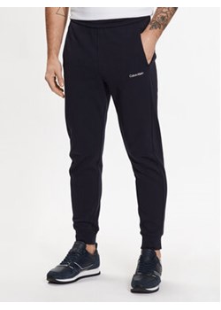 Calvin Klein Spodnie dresowe Micro Logo K10K109940 Granatowy Regular Fit ze sklepu MODIVO w kategorii Spodnie męskie - zdjęcie 168507445